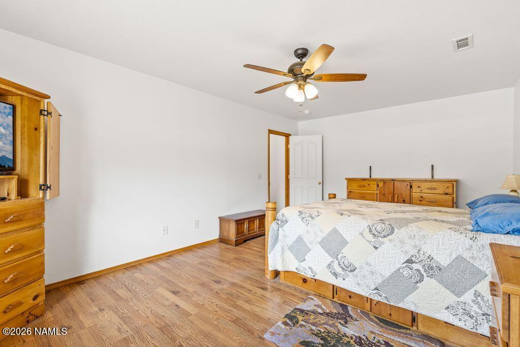7597 Conley Road Flagstaff, AZ 86004 - Photo 18 of 38 a bedroom with a bed and a chandelier
