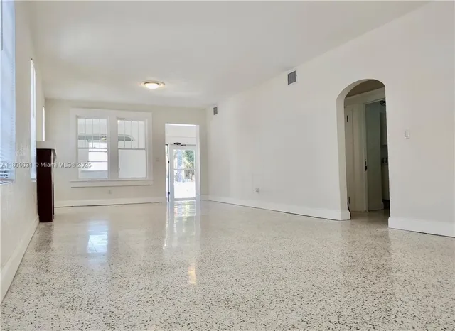 an empty room with windows and entrance