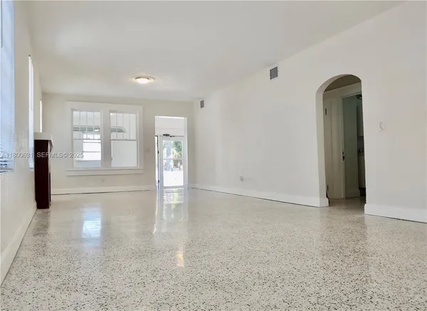 an empty room with windows and entrance