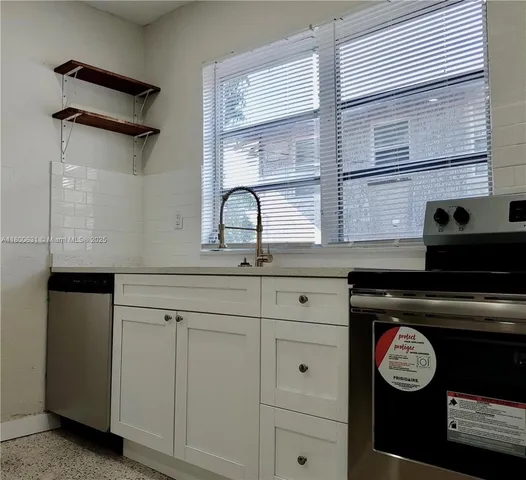 a view of cabinets a oven and a window