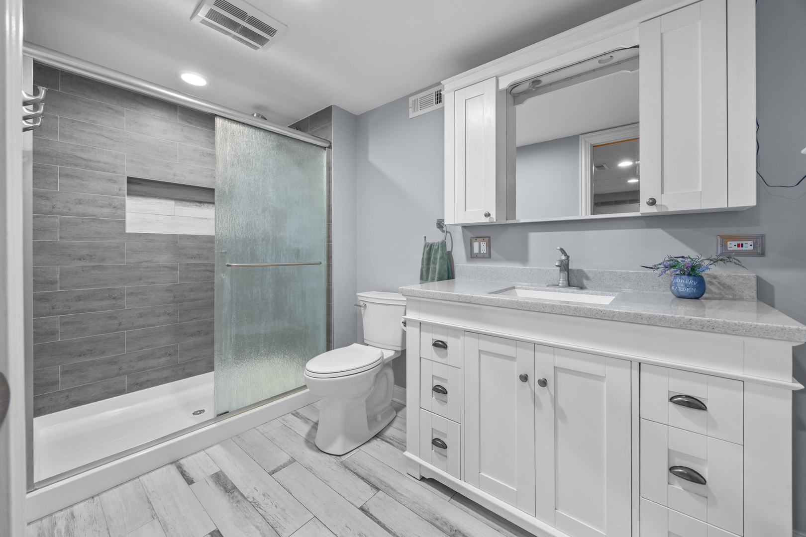1505 Chartwell Road Hoffman Estates, IL 60169 - Photo 27 of 38 a bathroom with a toilet a sink a glass door a shower a mirror and