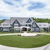 a view of a big house with a big yard and large tree