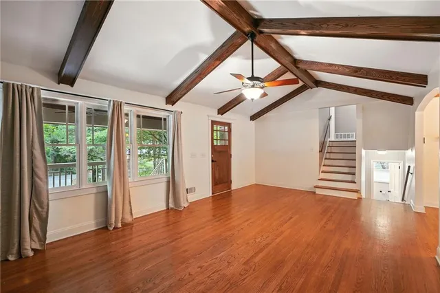 a view of empty room with wooden floor