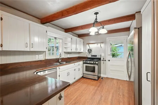 a kitchen with granite countertop white cabinets and white appliances