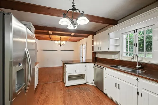 a kitchen with stainless steel appliances granite countertop a refrigerator a stove and a wooden floors