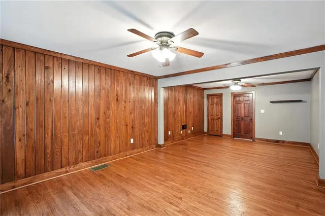 an empty room with closet and a ceiling fan