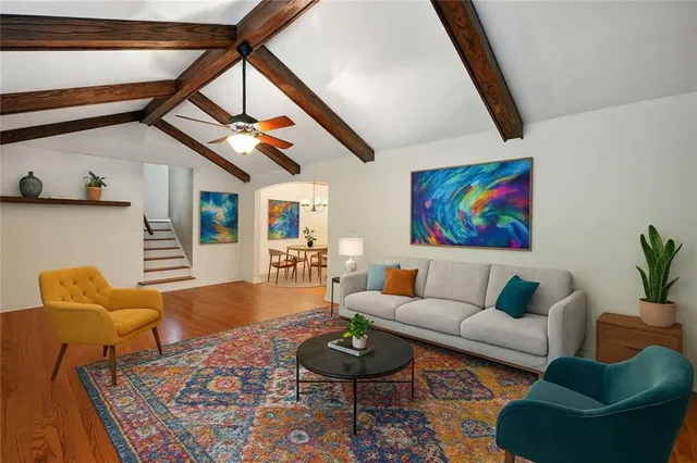 a living room with furniture a rug and a window