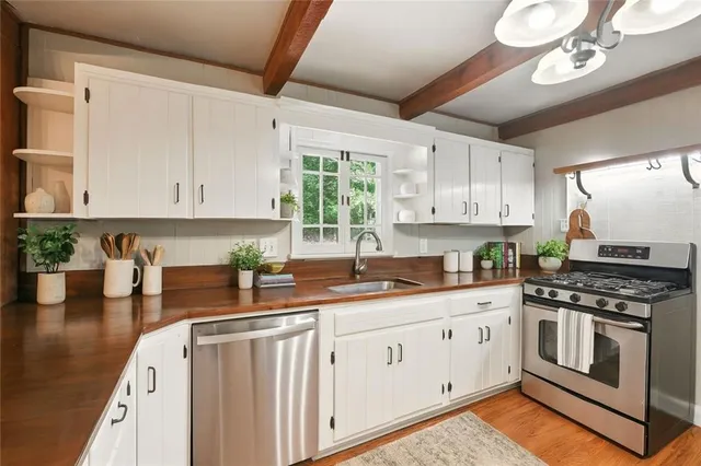 a kitchen with cabinets appliances a sink and a counter top space