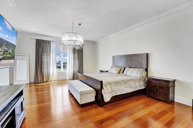 a spacious bedroom with a bed and wooden floor
