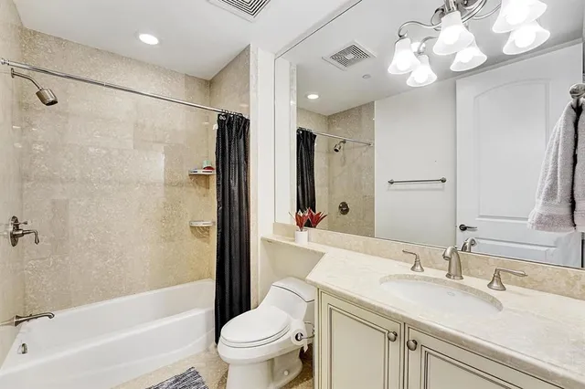 a bathroom with a sink a toilet a mirror a bathtub and shower