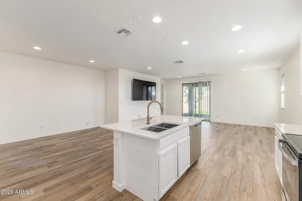 a kitchen with a sink cabinets and wooden floor