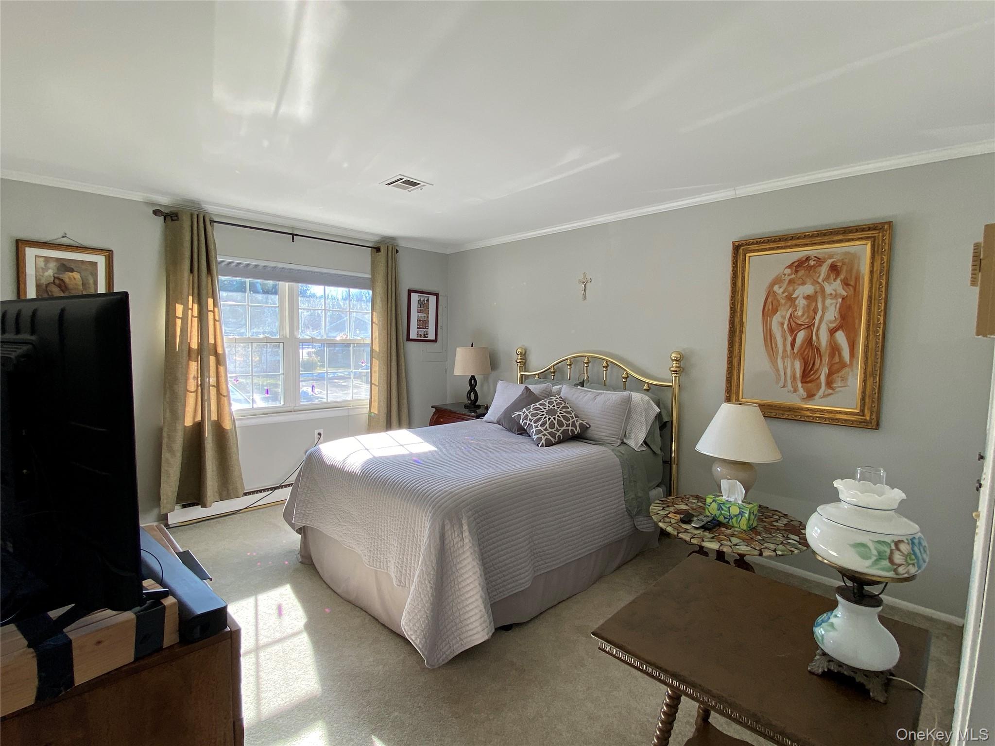 274 Berwick Court, Unit A Ridge, NY 11961 - Photo 20 of 31 Carpeted bedroom with baseboard heating and ornamental molding