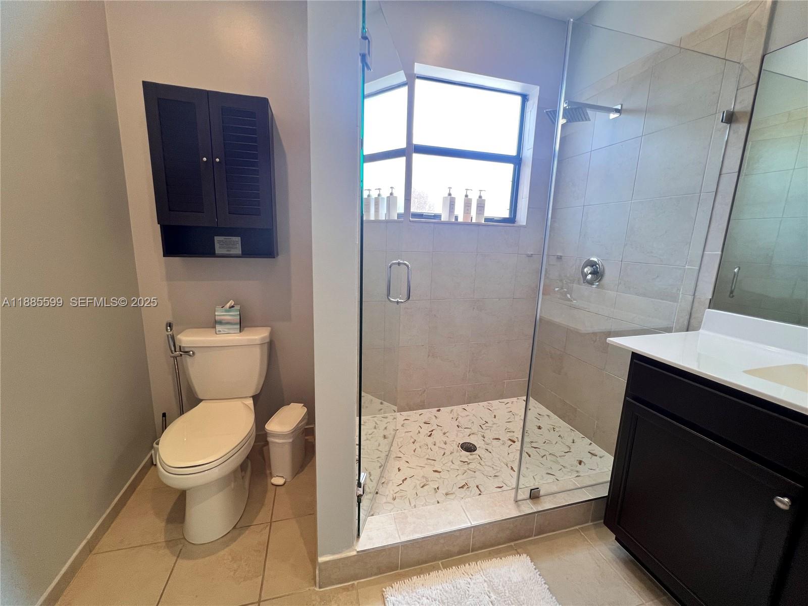 159 Southeast 34th Avenue Homestead, FL 33033 - Photo 13 of 27 a bathroom with a toilet a sink a shower a mirror and a window