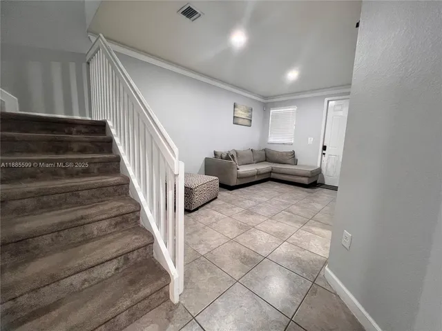 a living room with furniture and stairs