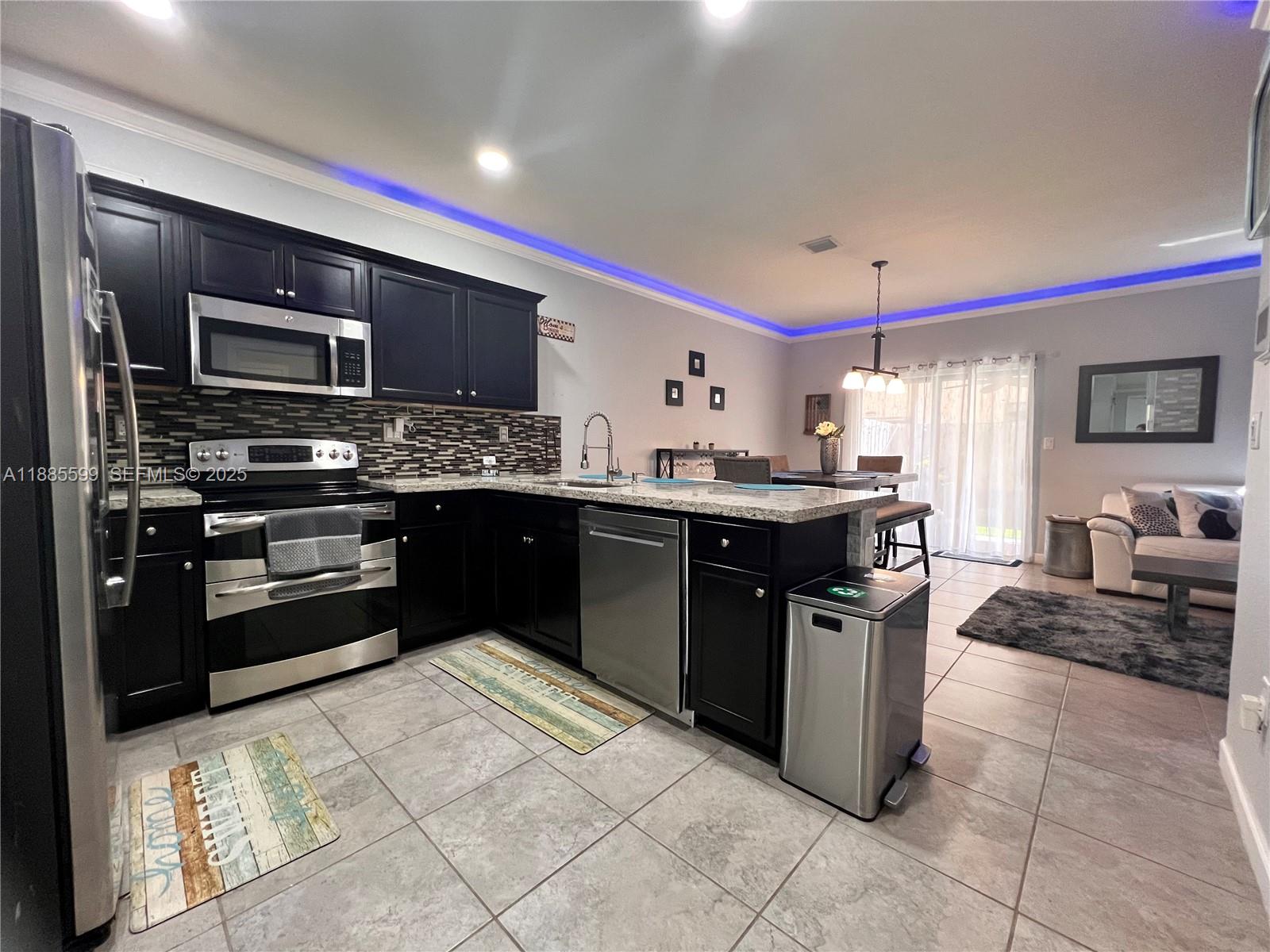 159 Southeast 34th Avenue Homestead, FL 33033 - Photo 6 of 27 a kitchen with stainless steel appliances granite countertop a stove a sink and a refrigerator
