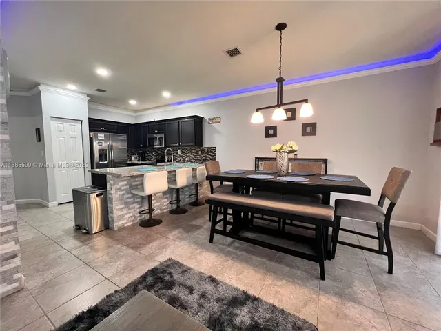 a kitchen with kitchen island granite countertop stainless steel appliances lots of counter space a sink and a wooden floors