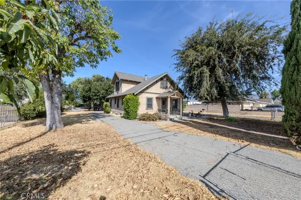 a front view of a house with a yard and trees