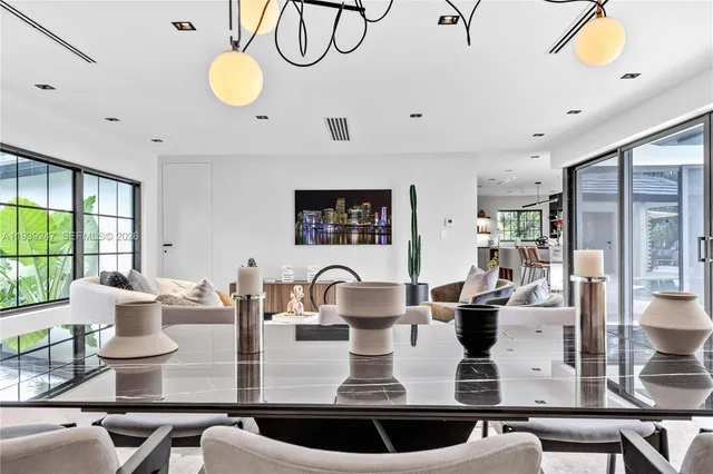 a living room with dining room and large windows