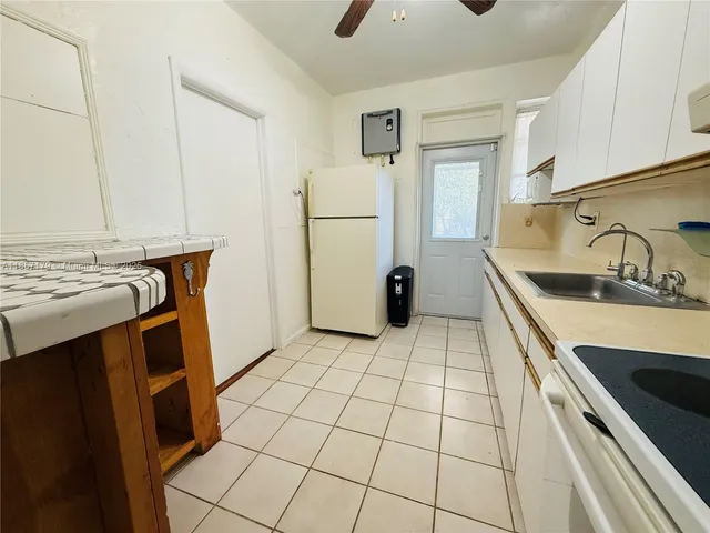 a kitchen with a sink a refrigerator and cabinets