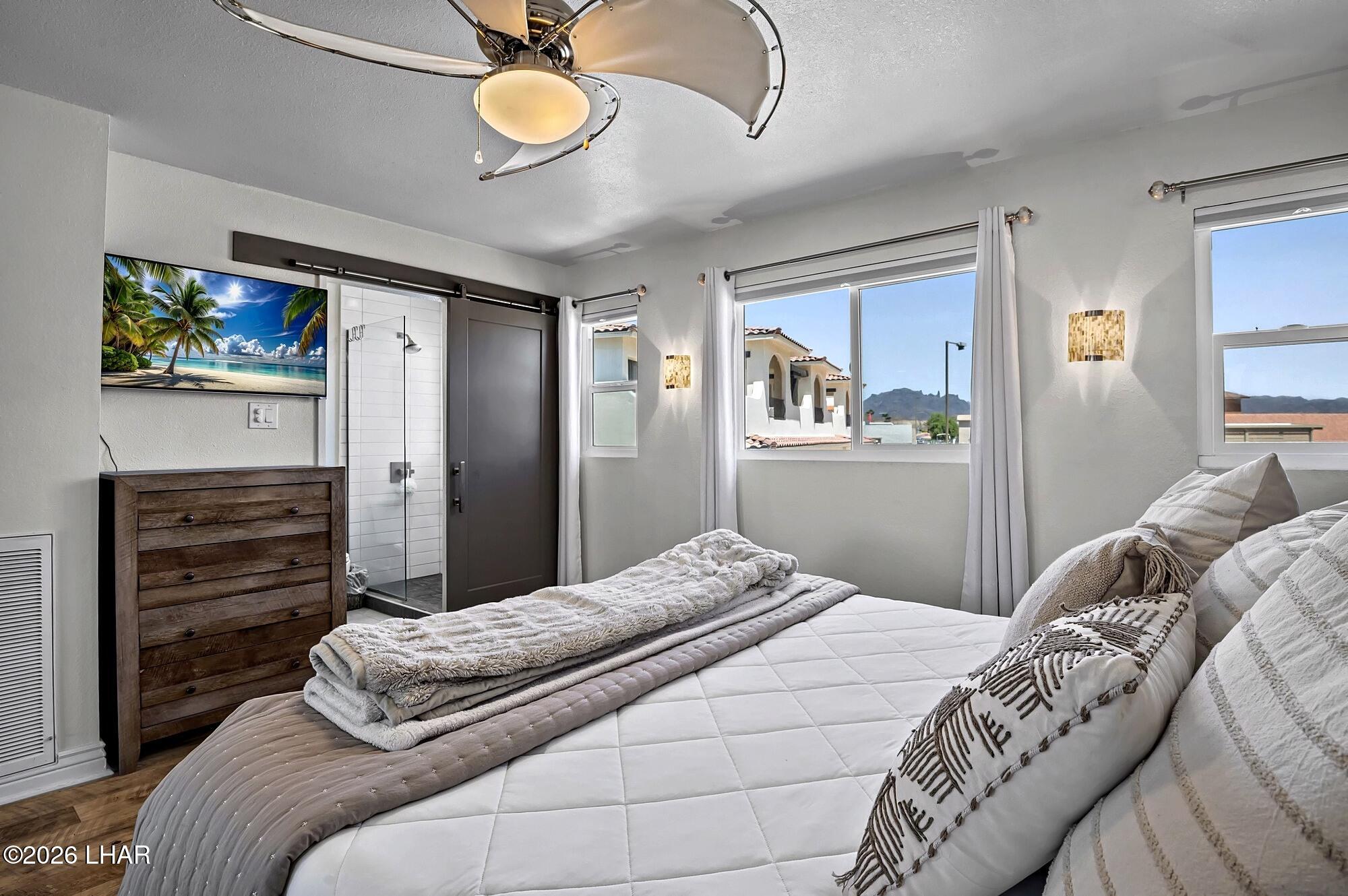 9170 Riverside Drive, Unit 13 Parker, AZ 85344 - Photo 25 of 51 a bedroom with a bed and a chandelier