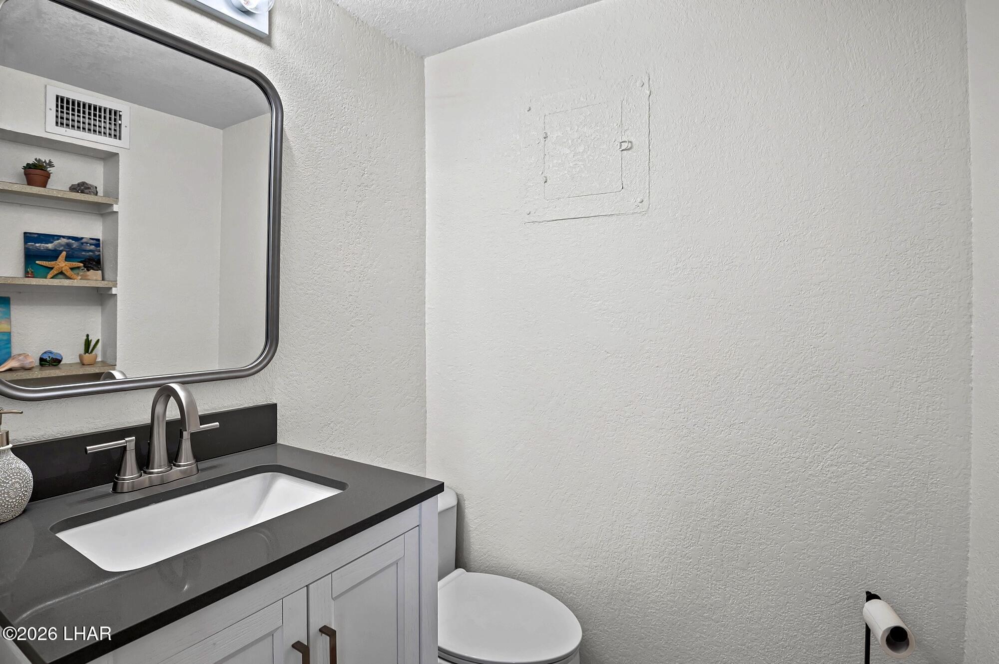 9170 Riverside Drive, Unit 13 Parker, AZ 85344 - Photo 30 of 51 a bathroom with a granite countertop sink toilet and a mirror