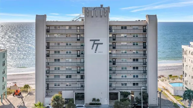 a large white kitchen with a white countertops a stove a dining table and chairs