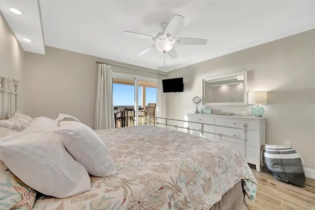 a spacious bedroom with a large bed and a flat tv screen