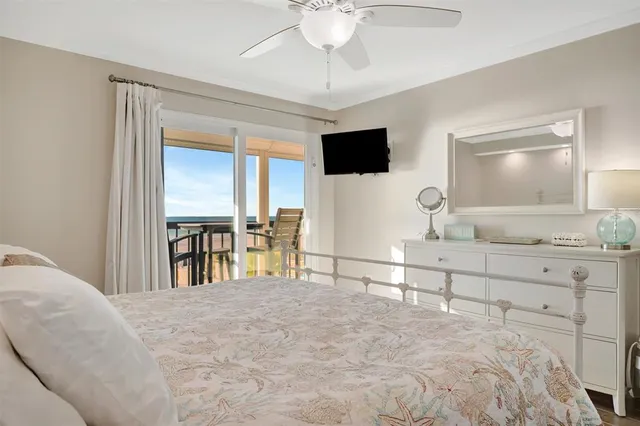 a bedroom with a large bed and a flat tv screen on dresser