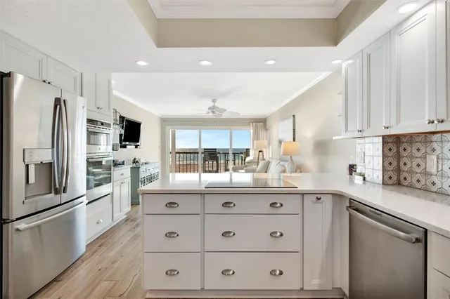 a large white kitchen with cabinets