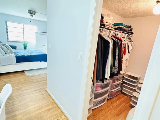 a view of walk in closet with clothes and shoes