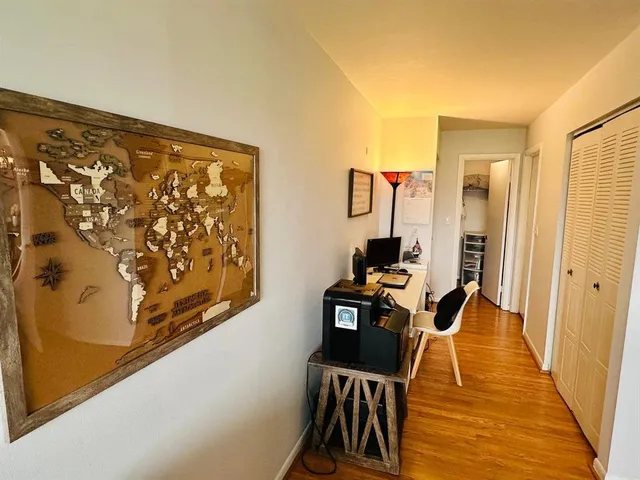 a living room with stainless steel appliances furniture a rug and a wooden floor