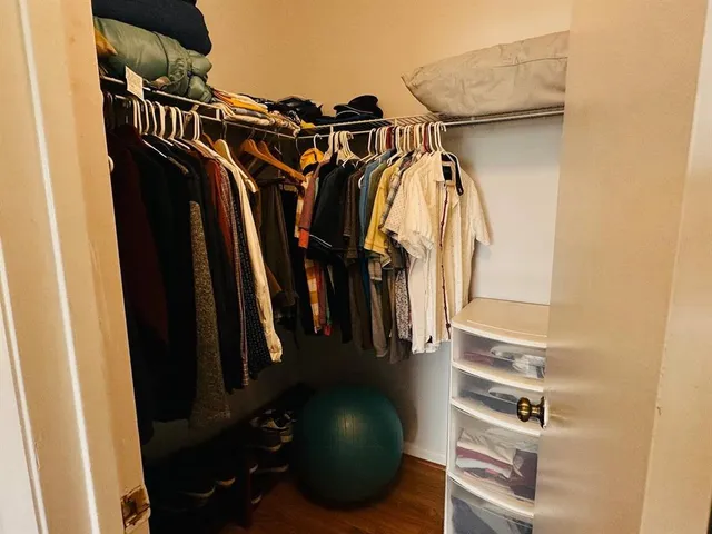 a view of walk in closet with clothes and shoes