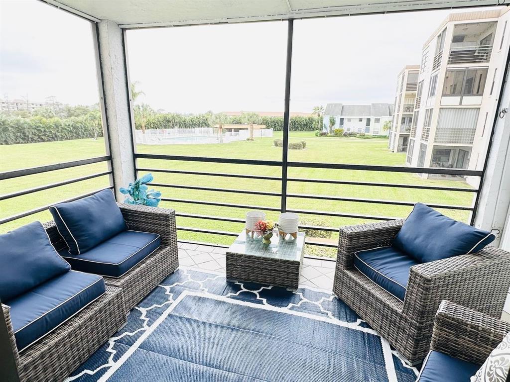 9300 Southwest 8th Street, Unit 214 Boca Raton, FL 33428 - Photo 29 of 32 a living room with furniture and a floor to ceiling window