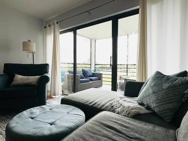 a living room with furniture and large windows