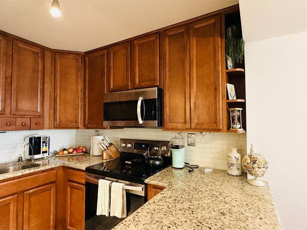 9300 Southwest 8th Street, Unit 214 Boca Raton, FL 33428 - Photo 10 of 32 a kitchen with a sink stove and cabinets