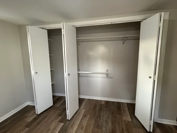 a view of walk in closet with wooden floor