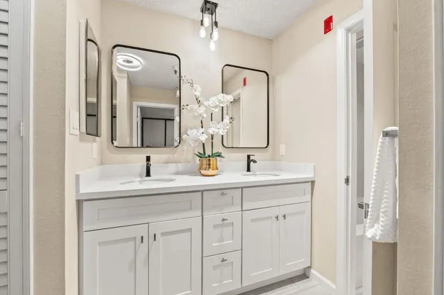 a bathroom with a double vanity sink mirror and