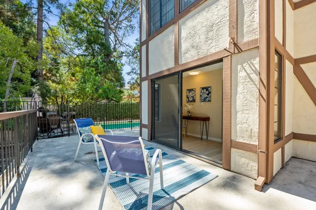 a patio with glass top table and chairs