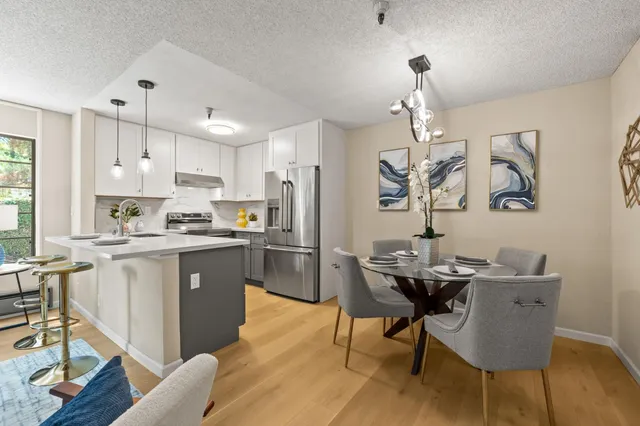 a kitchen with granite countertop white cabinets stainless steel appliances and dining table