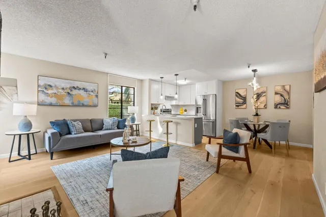 a living room with furniture and a dining table with wooden floor