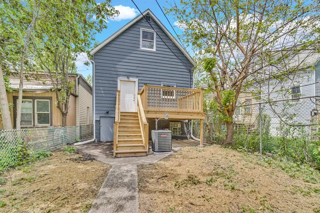 a backyard of a house with barbeque oven and outdoor seating