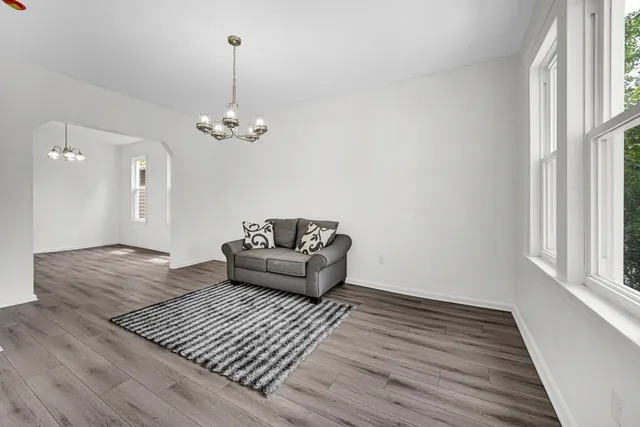 a living room with furniture and a chandelier