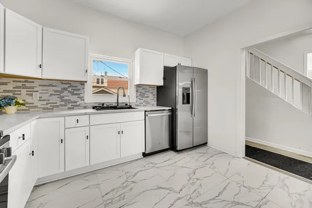 a kitchen with a refrigerator sink and cabinets