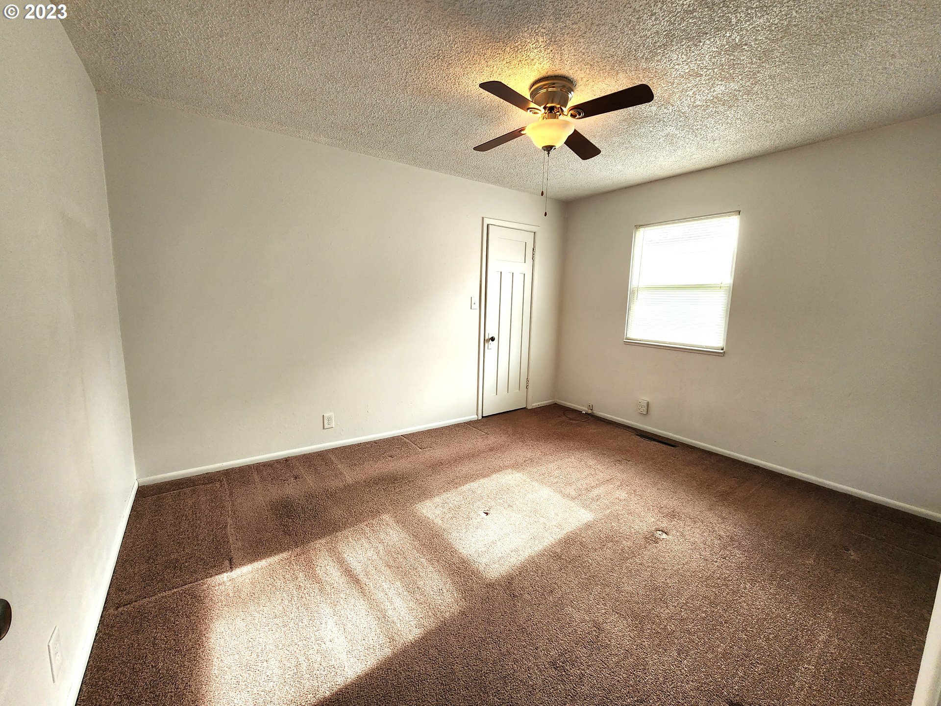 809 15th Street La Grande, OR 97850 - Photo 8 of 11 an empty room with windows and fan