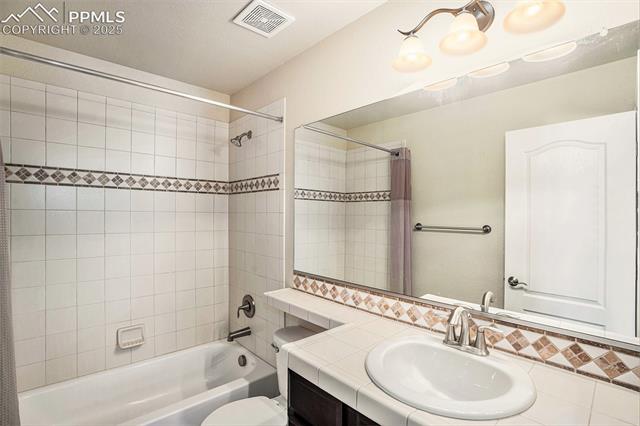 9709 Rockingham Drive Peyton, CO 80831 - Photo 24 of 50 Main floor full bath with shower / bath combination, toilet, backsplash, and vanity