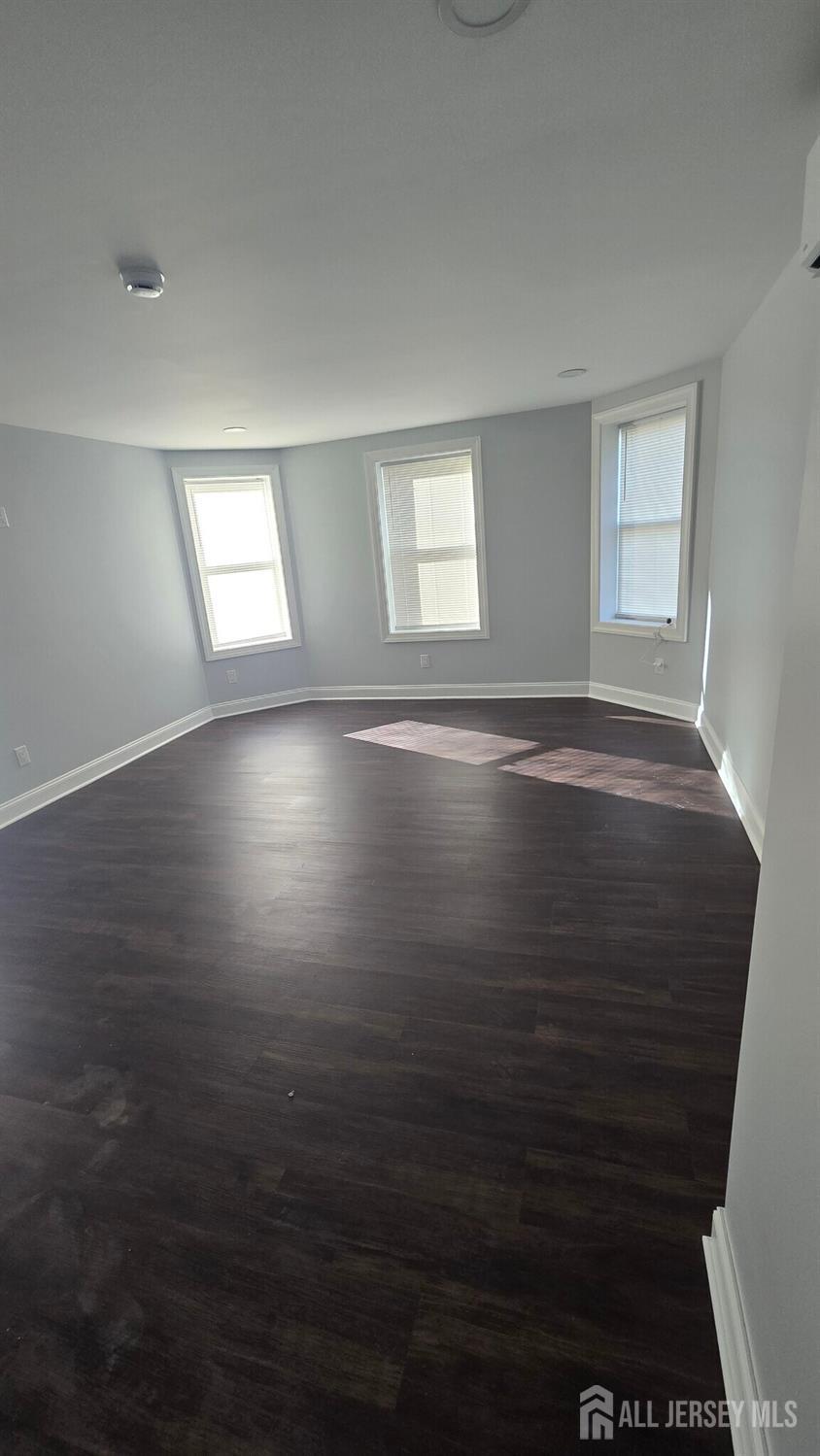 272 Market Street Perth Amboy, NJ 08861 - Photo 15 of 20 an empty room with wooden floor and windows