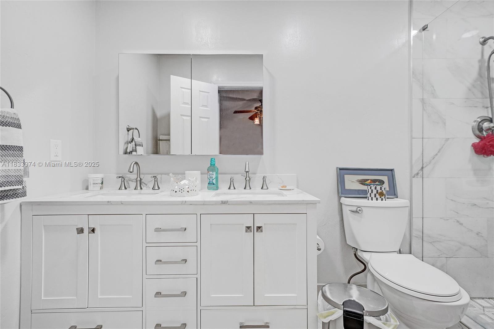 12763 Southwest 45th Terrace Miami, FL 33175 - Photo 13 of 30 a bathroom with a toilet a sink a mirror and vanity
