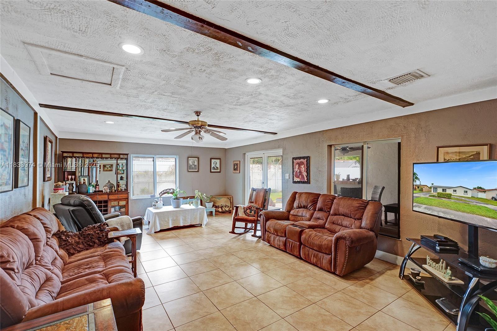 12763 Southwest 45th Terrace Miami, FL 33175 - Photo 20 of 30 a living room with furniture ceiling fan and a rug
