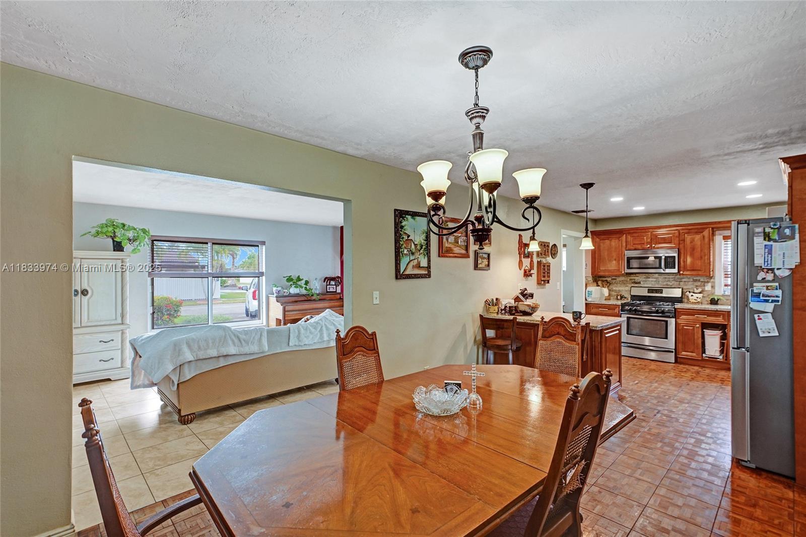 12763 Southwest 45th Terrace Miami, FL 33175 - Photo 7 of 30 a living room with dining table furniture and a chandelier