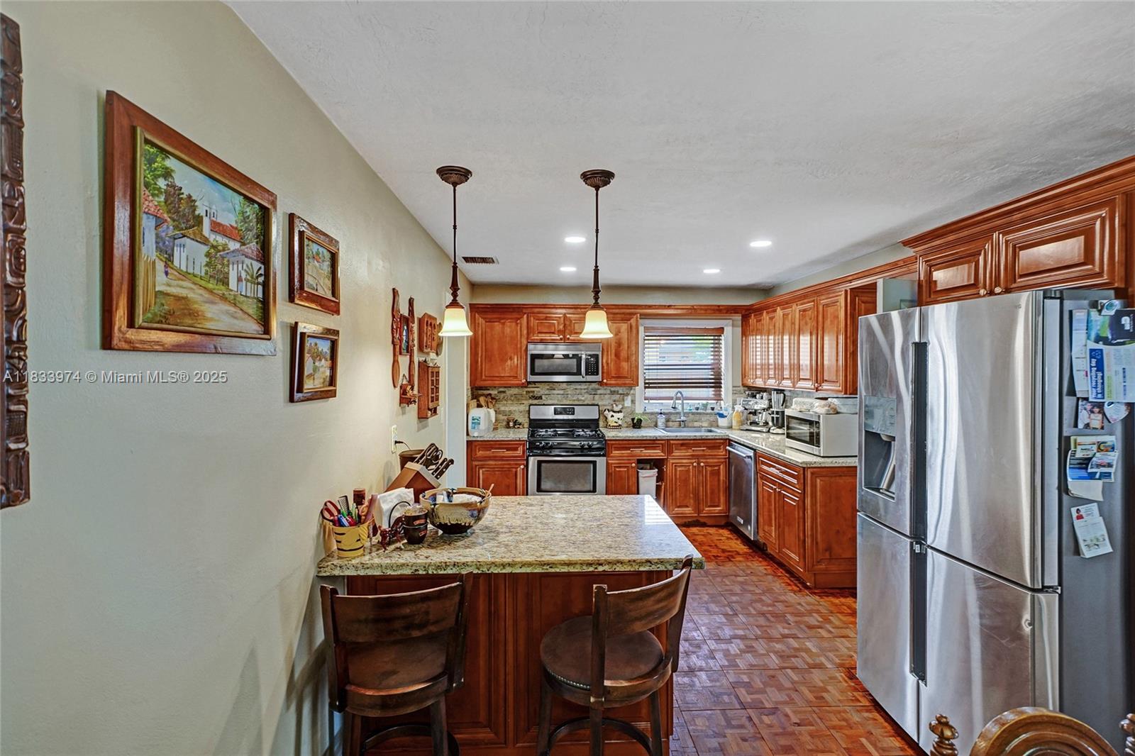 12763 Southwest 45th Terrace Miami, FL 33175 - Photo 10 of 30 a kitchen with stainless steel appliances granite countertop a dining table chairs refrigerator and sink